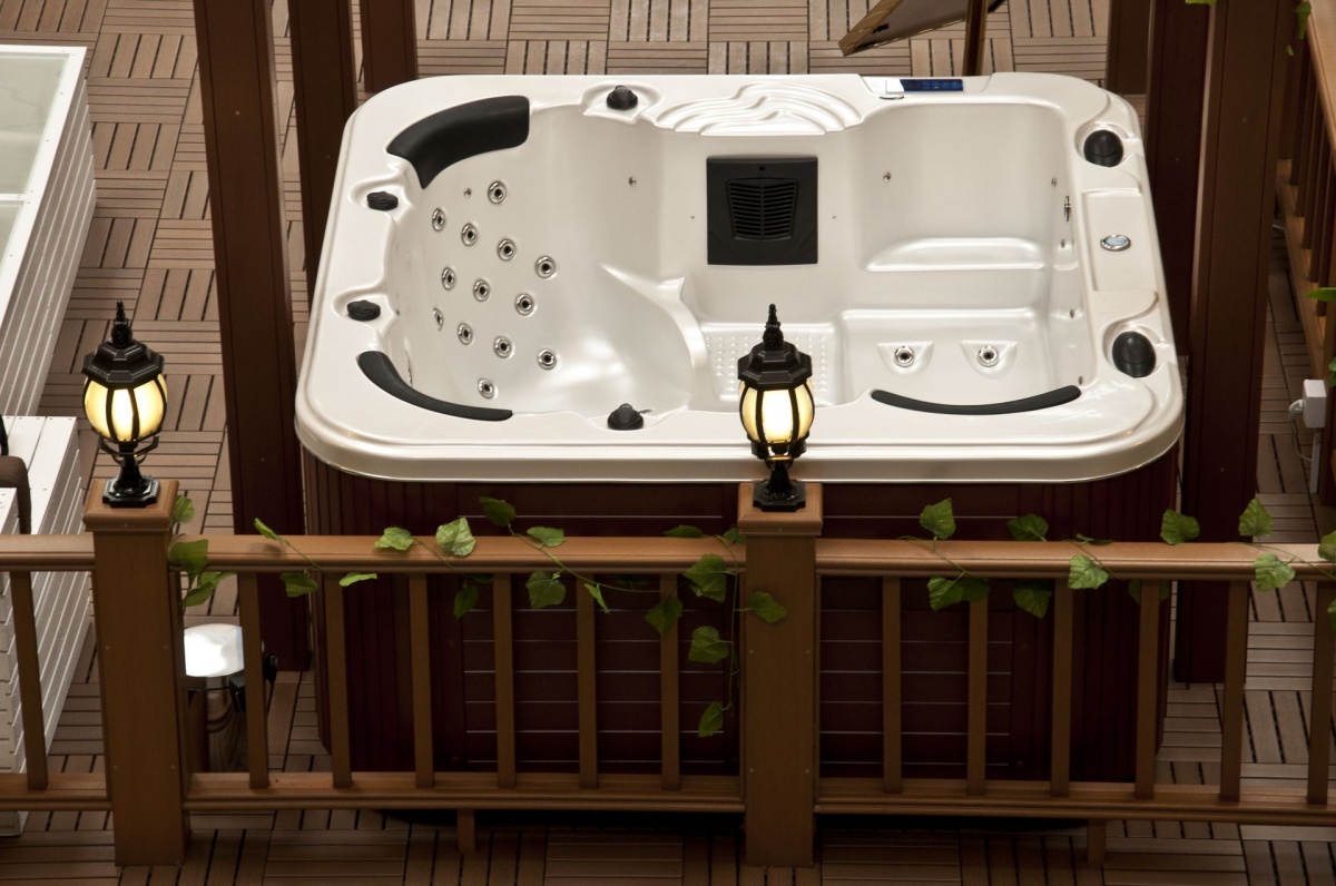 0 5 » Health By Fun health by fun white outdoor hot tub on a wooden deck with built-in seating and jet nozzles; lanterns on the railing nearby.